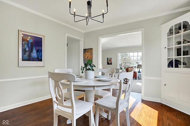 dining room with an inviting chandelier, dark wood-style floors, and ornamental molding