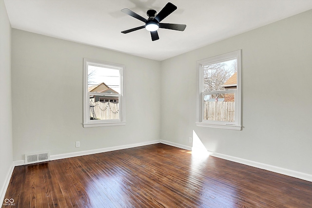 empty room featuring a ceiling fan, wood finished floors, visible vents, and baseboards