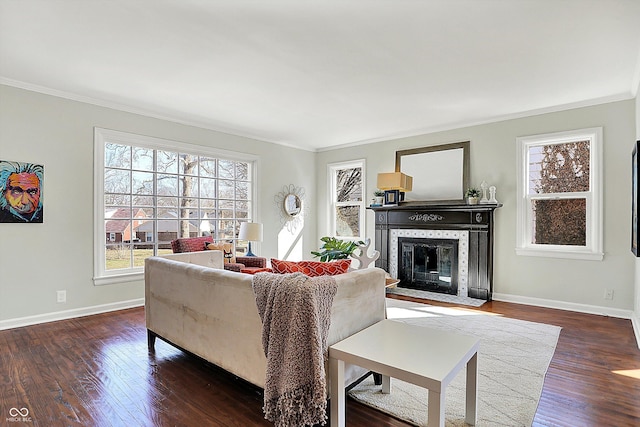 living room with a tiled fireplace, wood finished floors, baseboards, and ornamental molding