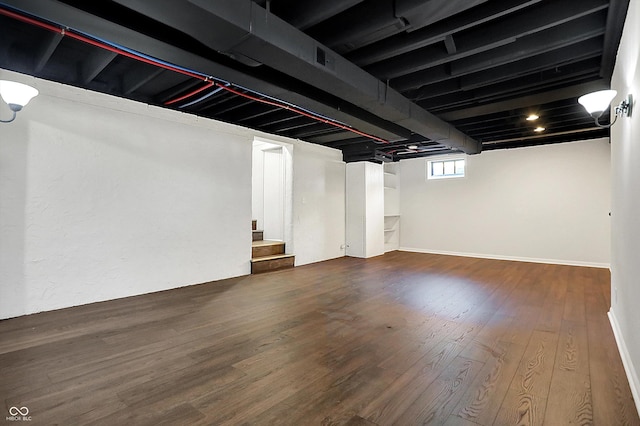 below grade area featuring stairway and wood finished floors