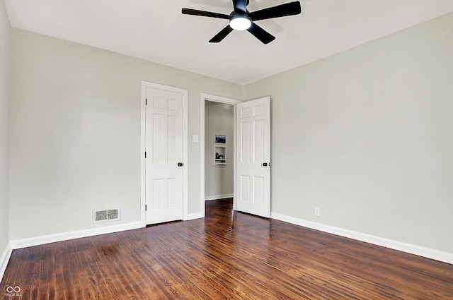 unfurnished room featuring ceiling fan, visible vents, baseboards, and wood finished floors