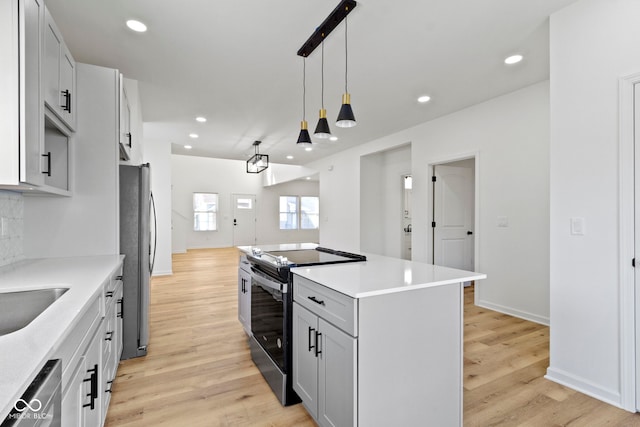 kitchen with recessed lighting, stainless steel appliances, a center island, and light wood finished floors