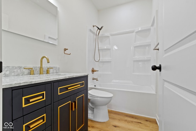 full bathroom featuring vanity, toilet, wood finished floors, and tub / shower combination