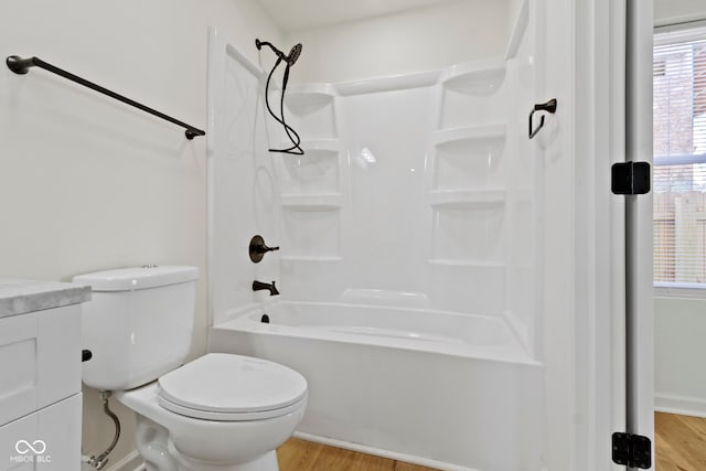 full bath featuring vanity, toilet, wood finished floors, and tub / shower combination