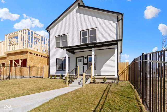 view of front facade featuring a porch, a fenced backyard, and a front yard