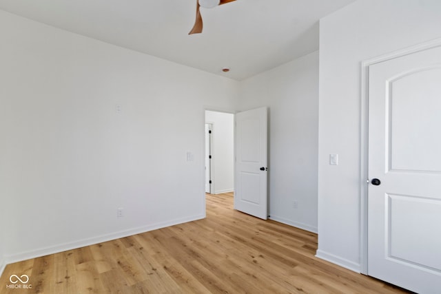 unfurnished bedroom with a ceiling fan, baseboards, and light wood-type flooring