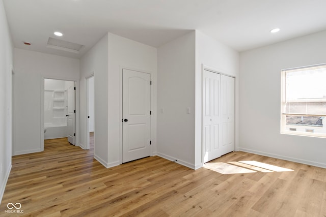 interior space featuring light wood finished floors, recessed lighting, attic access, and baseboards