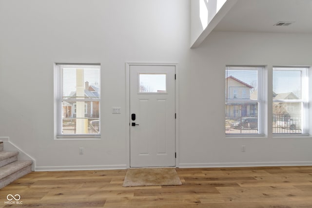 entryway featuring visible vents, baseboards, light wood-style flooring, and stairway