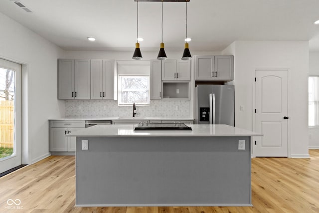 kitchen featuring a sink, stainless steel appliances, a kitchen island, and gray cabinetry