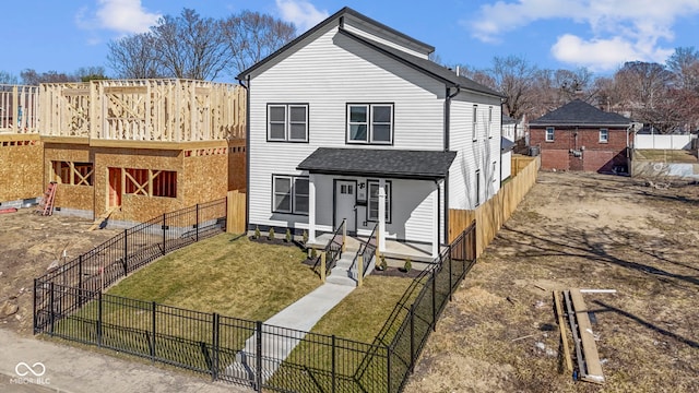 view of front of property with fence, a porch, roof with shingles, a front yard, and an outdoor structure