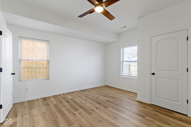 interior space featuring visible vents, baseboards, a ceiling fan, and light wood finished floors