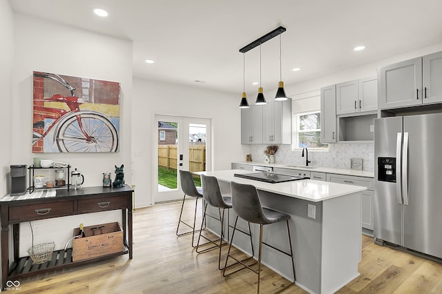 35 N Keystone Ave, Indianapolis, IN 46201 - kitchen with a sink, light wood-style flooring, a kitchen island, stovetop, and stainless steel fridge with ice dispenser