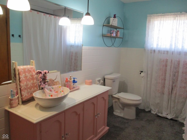 bathroom featuring vanity, a shower with shower curtain, wainscoting, tile walls, and toilet