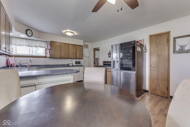 1459 S Josephine St, Martinsville, IN 46151 - kitchen with stainless steel appliances, ceiling fan, a sink, dark countertops, and light wood finished floors