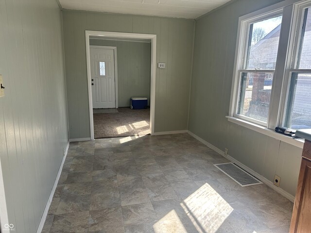 unfurnished room with visible vents and baseboards