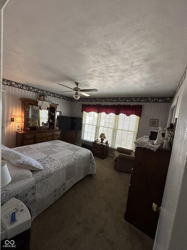 bedroom featuring a ceiling fan, a textured ceiling, and carpet flooring