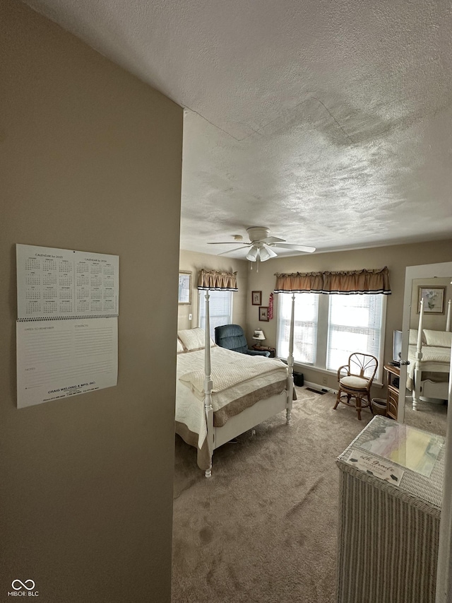 carpeted bedroom featuring a textured ceiling and a ceiling fan