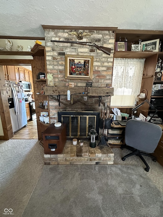 living room featuring a brick fireplace, a textured ceiling, and carpet floors