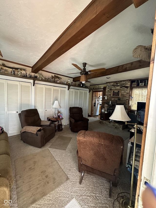 carpeted living room with beamed ceiling, a textured ceiling, and a ceiling fan