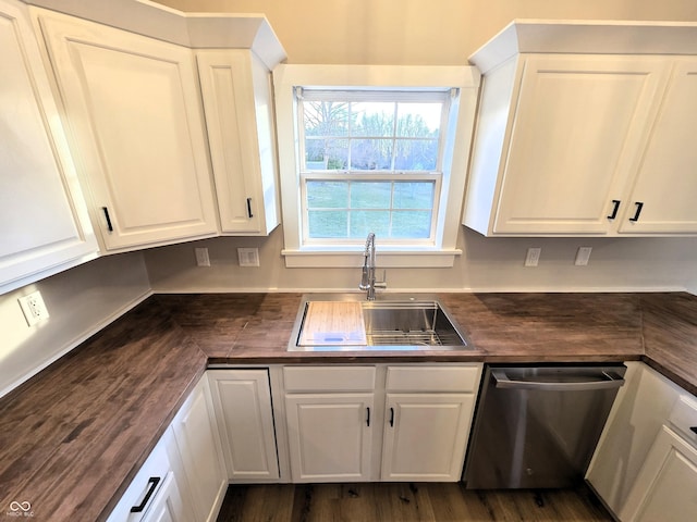 kitchen with stainless steel dishwasher, butcher block counters, white cabinets, and a sink