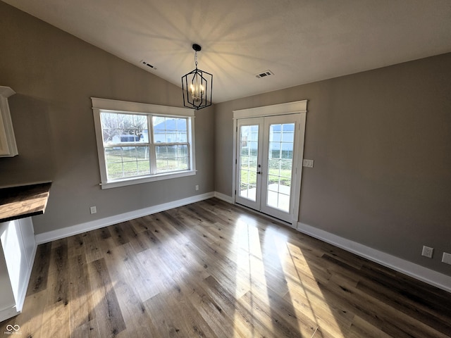 unfurnished dining area featuring lofted ceiling, wood finished floors, visible vents, and baseboards