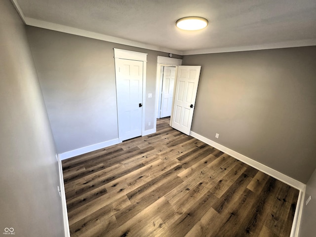 unfurnished bedroom featuring baseboards and wood finished floors