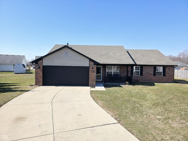 ranch-style house featuring brick siding, a garage, concrete driveway, and a front yard