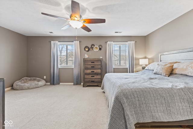 bedroom featuring multiple windows, light colored carpet, and visible vents