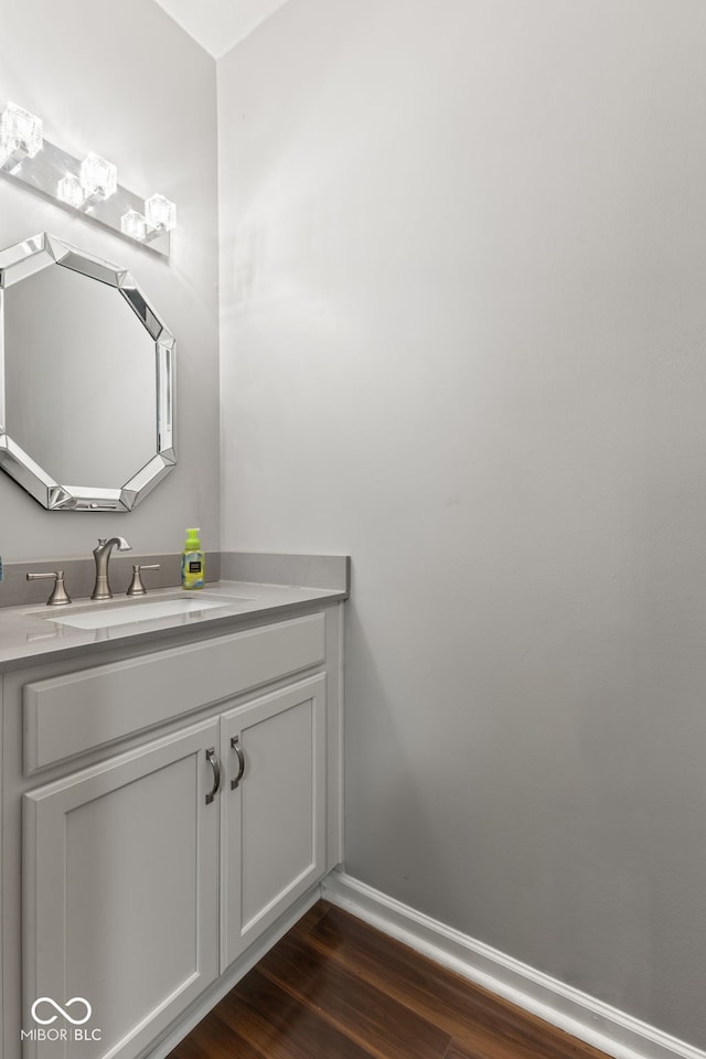 bathroom with vanity, baseboards, and wood finished floors