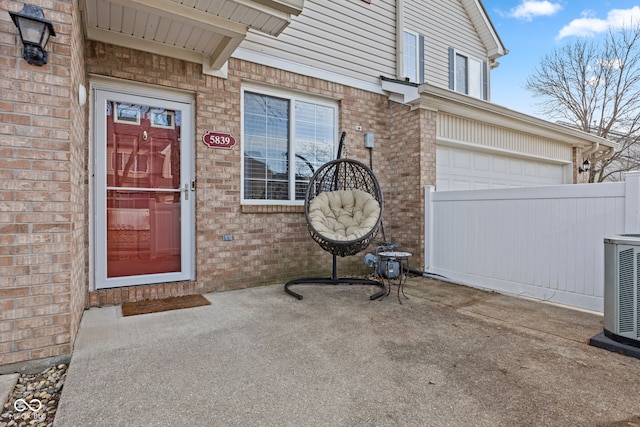 doorway to property featuring brick siding and central AC