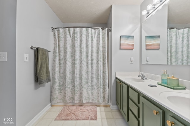 bathroom featuring double vanity, tile patterned floors, a textured ceiling, and a sink