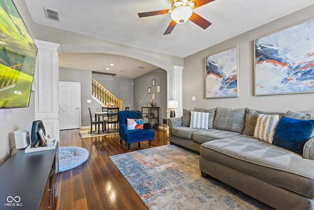 living area featuring visible vents, stairs, decorative columns, arched walkways, and wood-type flooring