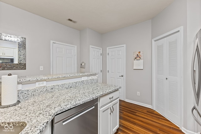 kitchen featuring visible vents, white cabinets, light stone countertops, dishwasher, and dark wood-style flooring