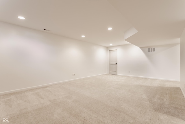 empty room with recessed lighting, visible vents, light colored carpet, and baseboards