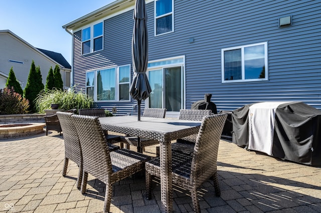 view of patio featuring outdoor dining space, an outdoor fire pit, and a grill