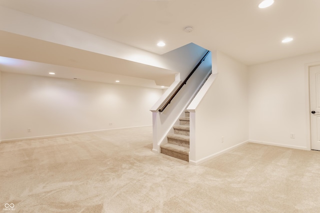 finished below grade area featuring recessed lighting, stairway, and light colored carpet