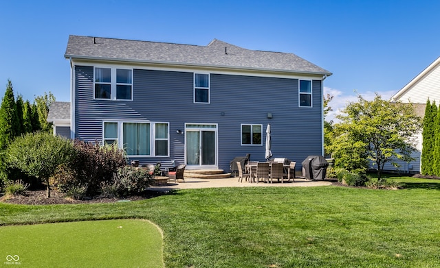 back of property with a yard, a patio, and roof with shingles