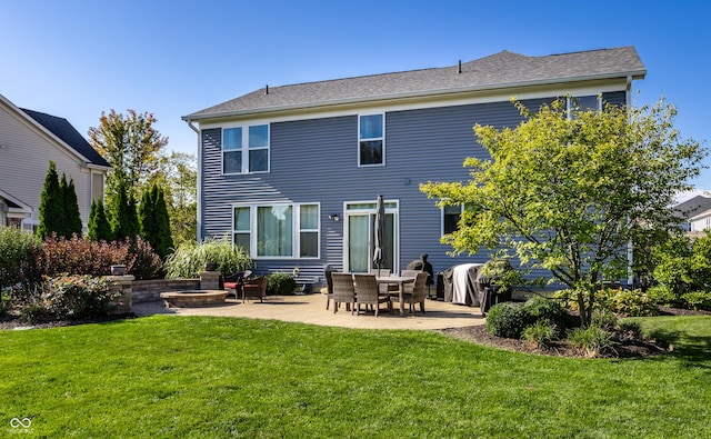 rear view of property with a patio, a lawn, and an outdoor fire pit