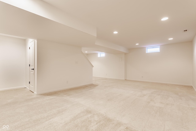 basement featuring recessed lighting, baseboards, and light carpet