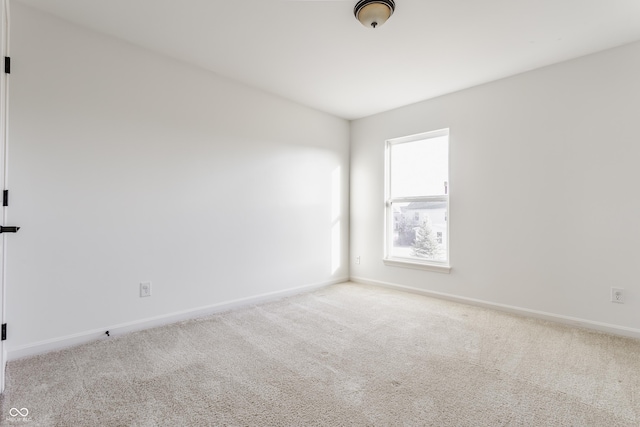 carpeted spare room with baseboards