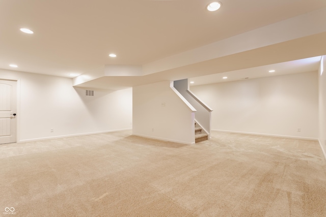 finished below grade area with recessed lighting, visible vents, light carpet, and stairs