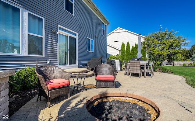 view of patio with outdoor dining space, an outdoor fire pit, and a grill