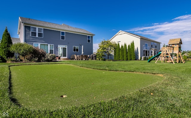 back of property with a yard and a playground