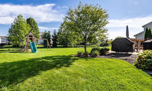 view of yard featuring a playground and a patio