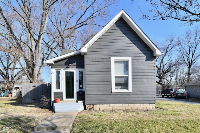 bungalow featuring a front yard and fence