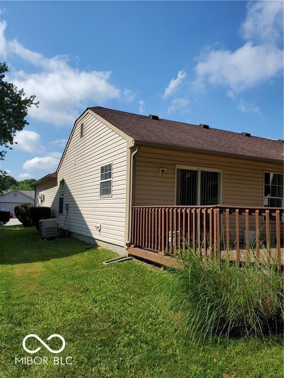 view of side of home featuring central AC and a yard