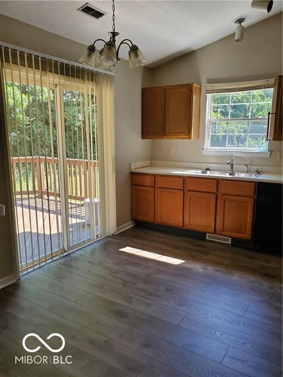 kitchen featuring vaulted ceiling, a sink, dark wood finished floors, and visible vents