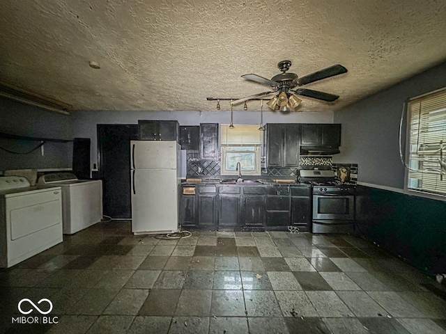 kitchen with stainless steel range with gas stovetop, a sink, freestanding refrigerator, and a healthy amount of sunlight