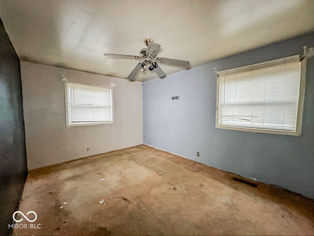 unfurnished room with visible vents, plenty of natural light, and ceiling fan