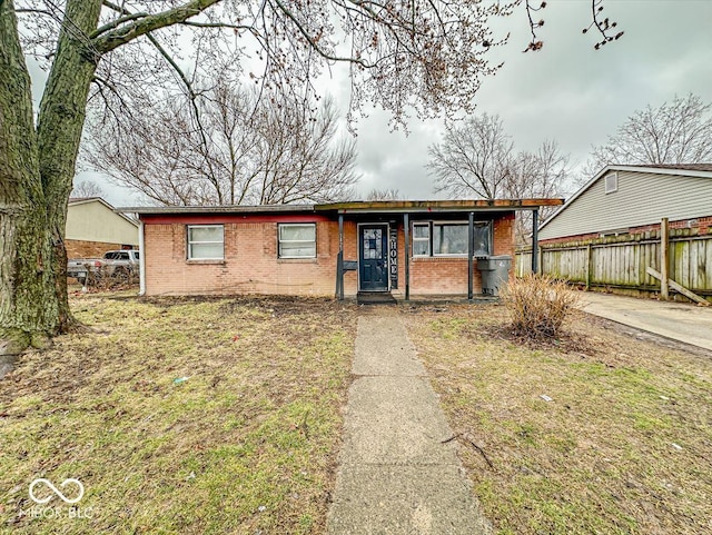 view of front of home featuring brick siding and fence